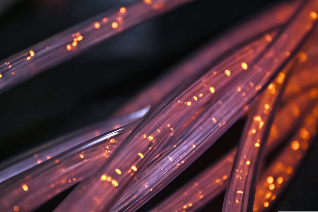 Makroaufnahme leuchtender Glasfaserkabel – moderne Highspeed-Internet- und Netzwerktechnologie für ultraschnelle Datenübertragung.