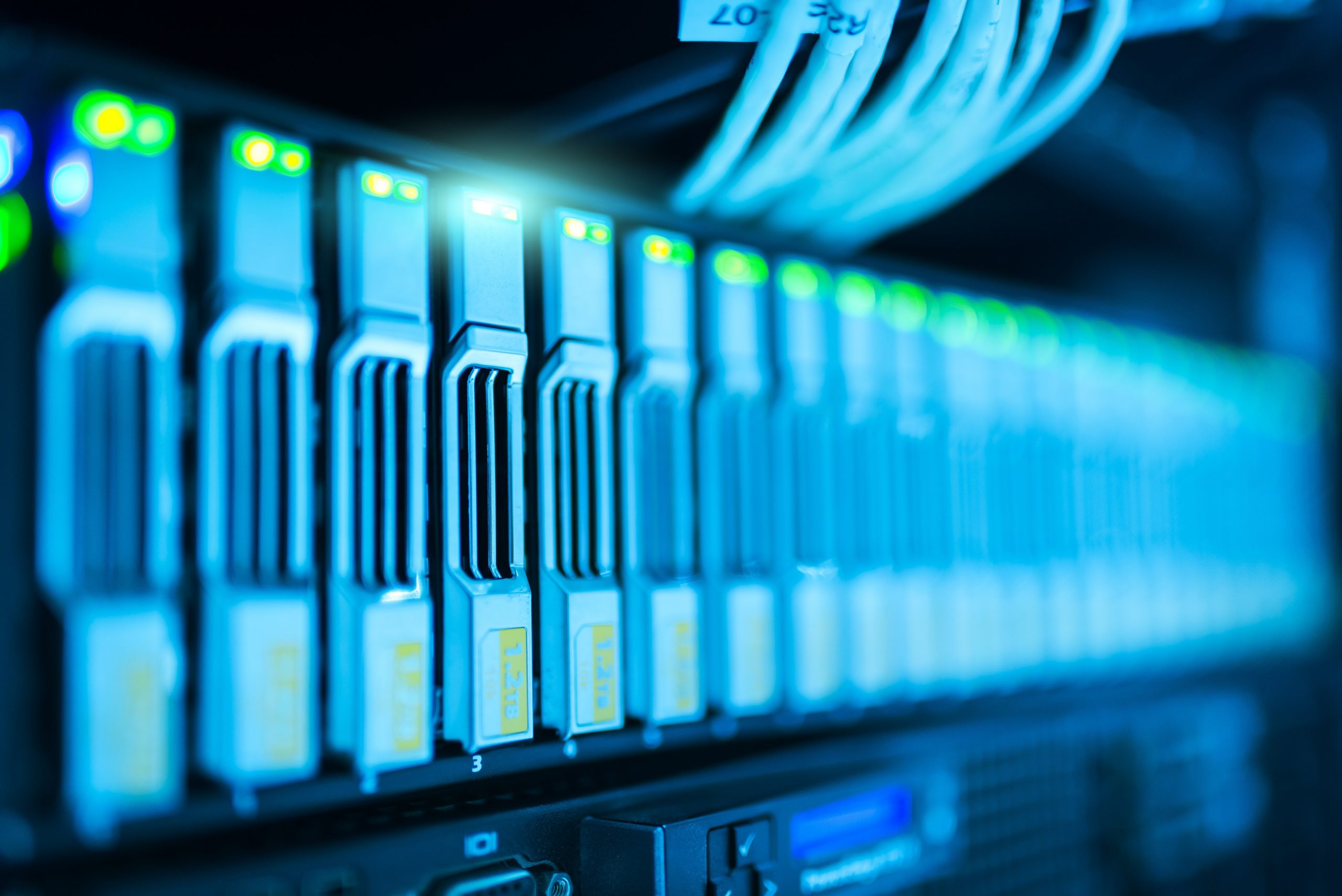Server mit leuchtenden Festplatteneinschüben und Netzwerkkabeln – zuverlässige Backup-Systeme und IT-Sicherheit für Unternehmen.